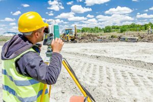 Engenheiro realizando demarcação topográfica de terreno com equipamento de alta precisão